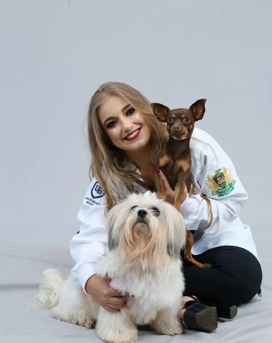 Médica veterinária da Vet Mais Três Fronteiras com dois cães no colo